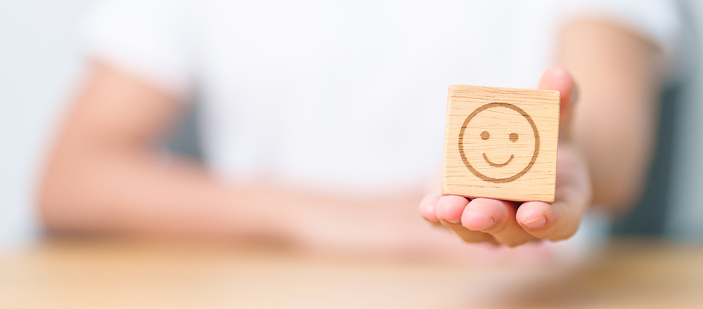 Cara feliz en un cubo de madera